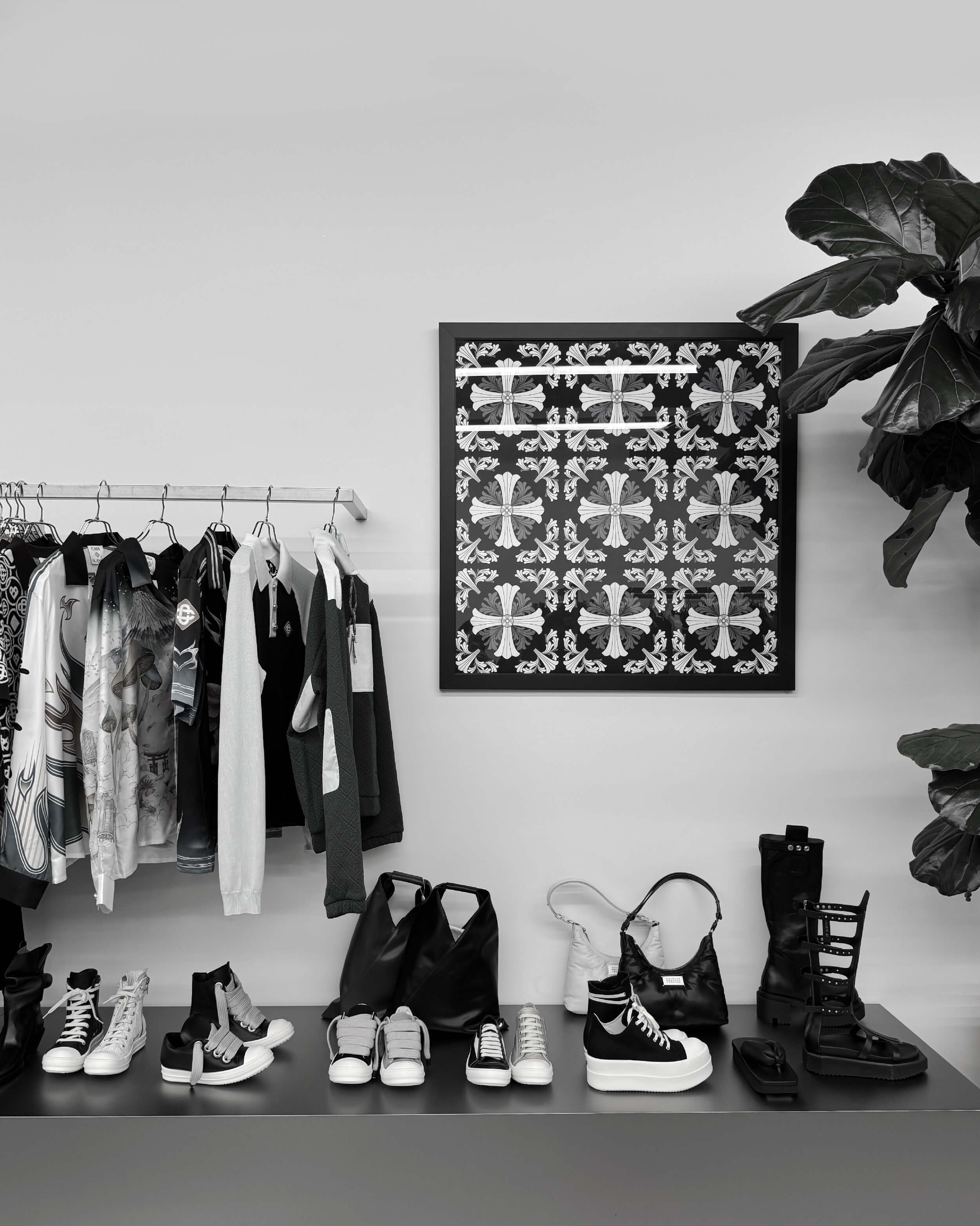 Clothing rack with Casablanca Paris clothes, Rick Owens shoes, and a chrome hearts wall art piece at Feuille