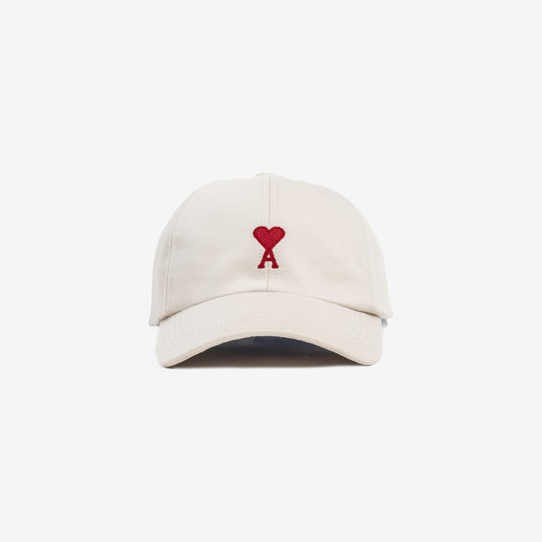 front view of beige cap with embroidered heart logo